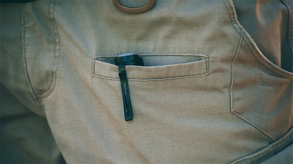 Close-up of a beige vest with a pocket containing a black object.