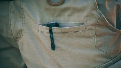 Close-up of a beige vest with a pocket containing a black object.