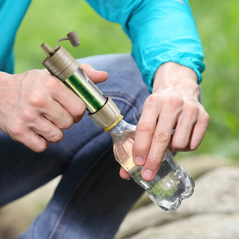 Person using a water filter to purify water outdoors