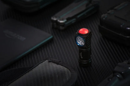 Small flashlight with red light on a dark surface