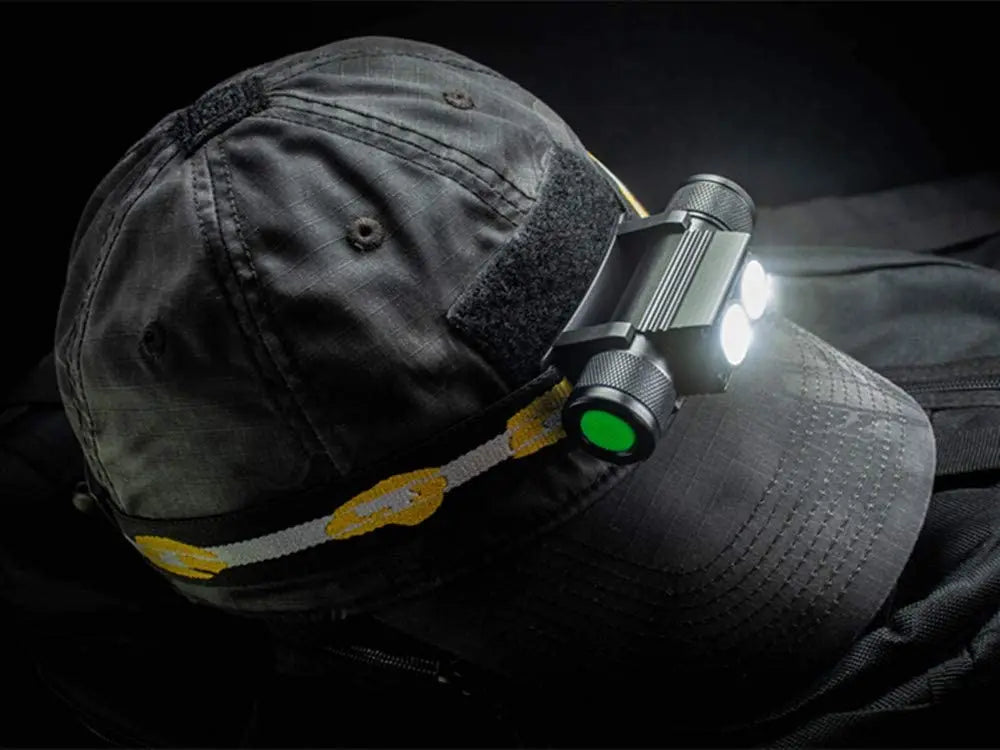 Person wearing a cap with a headlamp attached on a dark background
