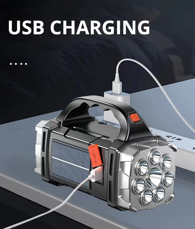 Handheld flashlight with USB cable charging on a dark background