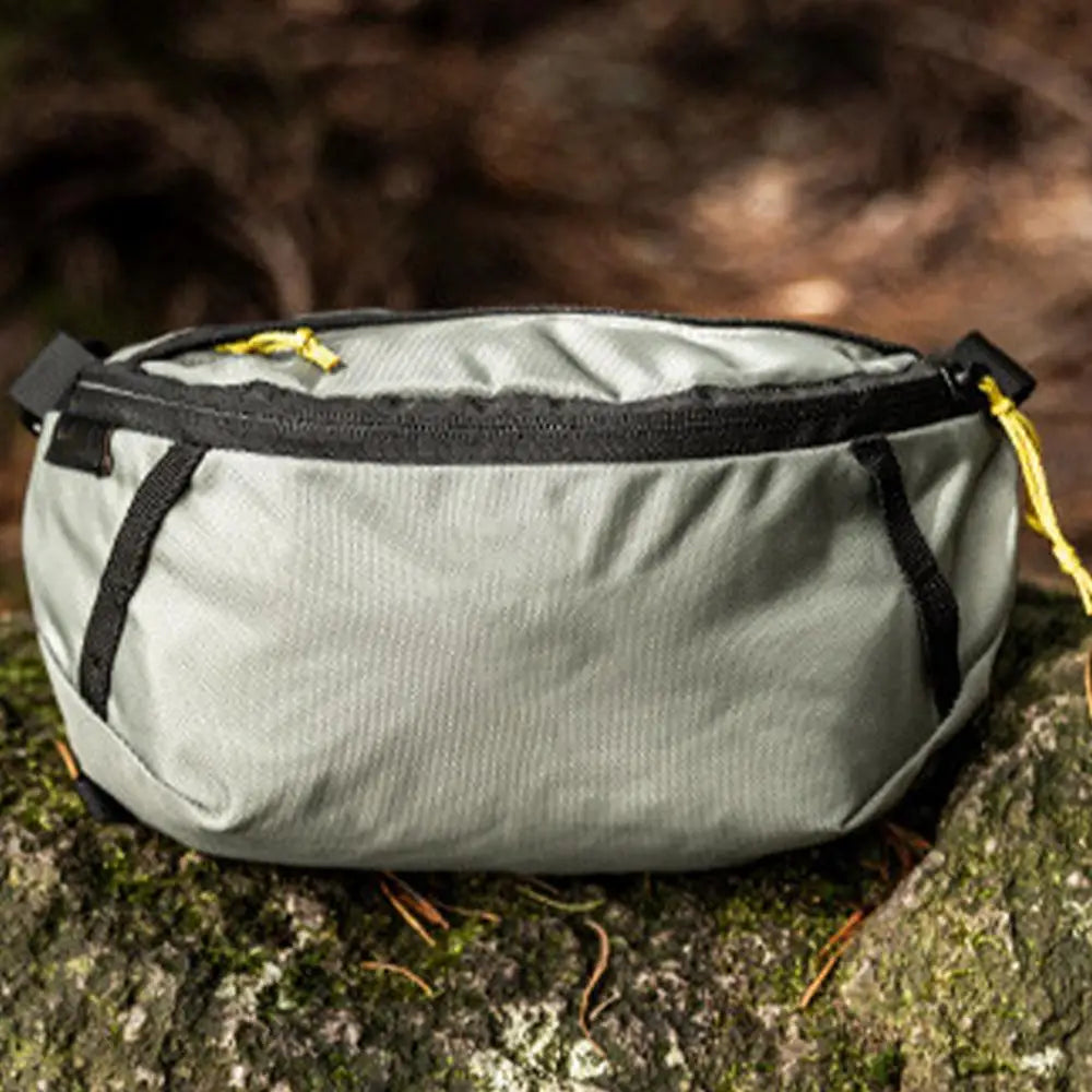 Gray pouch with black zipper on a textured surface