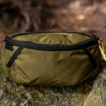 Green bag with a black strap on a natural background
