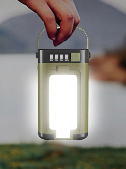 Hand holding a green camping lantern with a blurred background