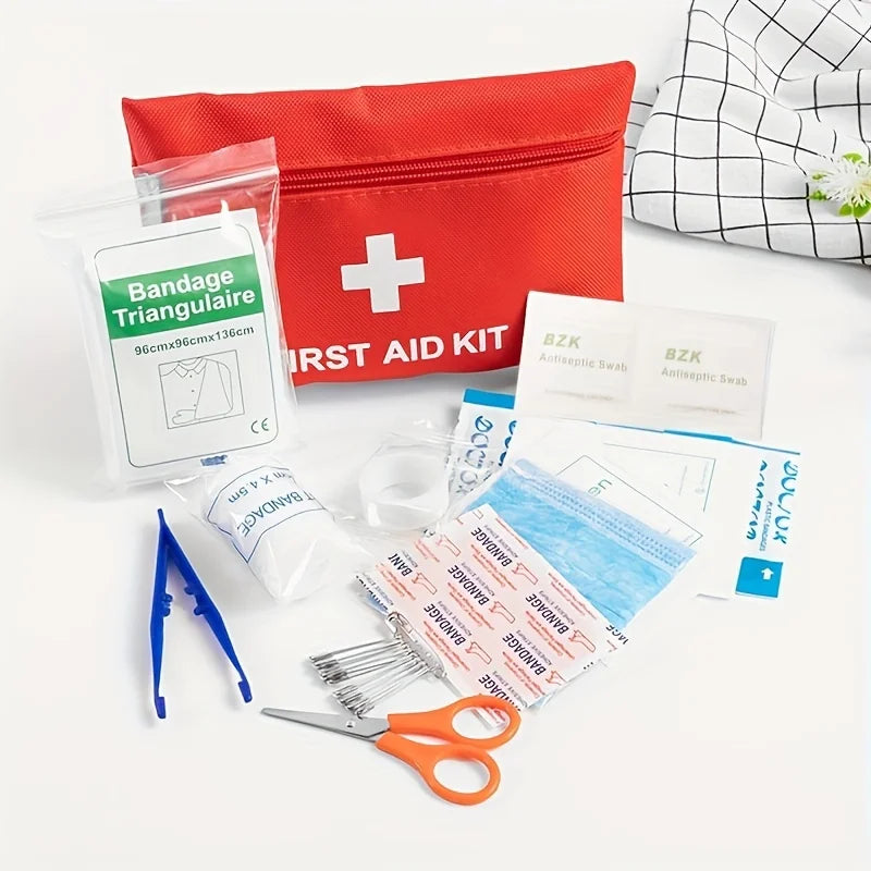 First aid kit with bandages, scissors, and other supplies on a white background