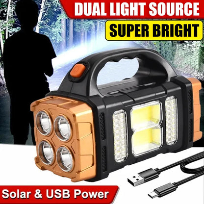 A rugged portable LED lantern flashlight with a black and copper-orange body, shown with a USB charging cable. The background features a silhouette of a person holding the light in a forest, with promotional text overlays reading 'DUAL LIGHT SOURCE', 'SUPER BRIGHT', 'Solar & USB Power'.