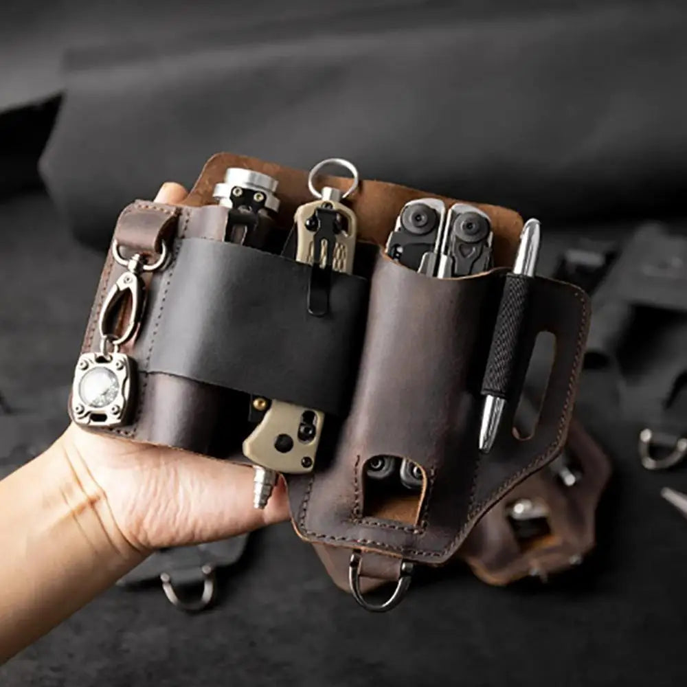 Brown leather key organizer with multiple keys and tools held by a hand against a dark background