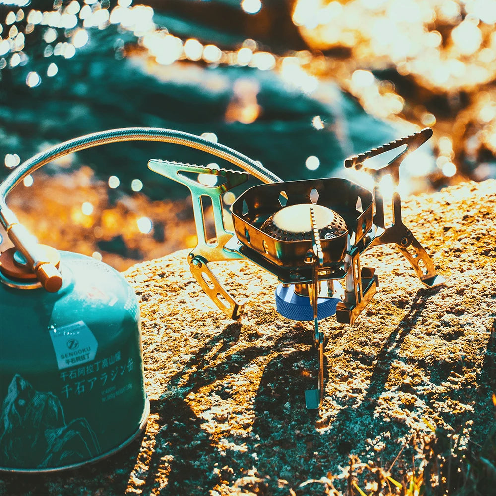 Camp stove and fuel canister on a rock with a blurred natural background