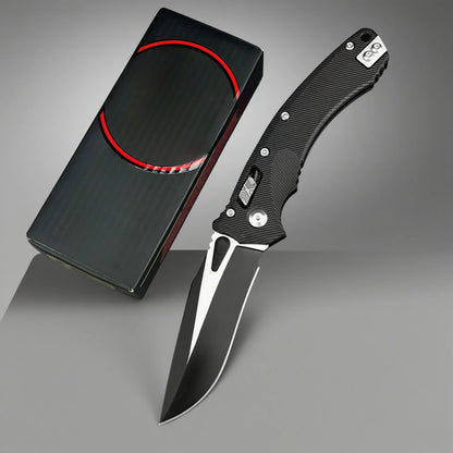 Folding knife with black handle and silver blade next to a black sheath on a gray background