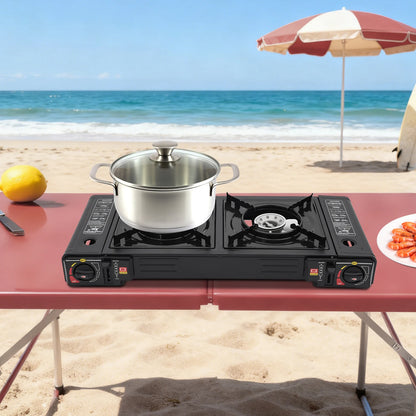 Portable gas stove with a pot on a beach table, lemon and plate of food nearby.