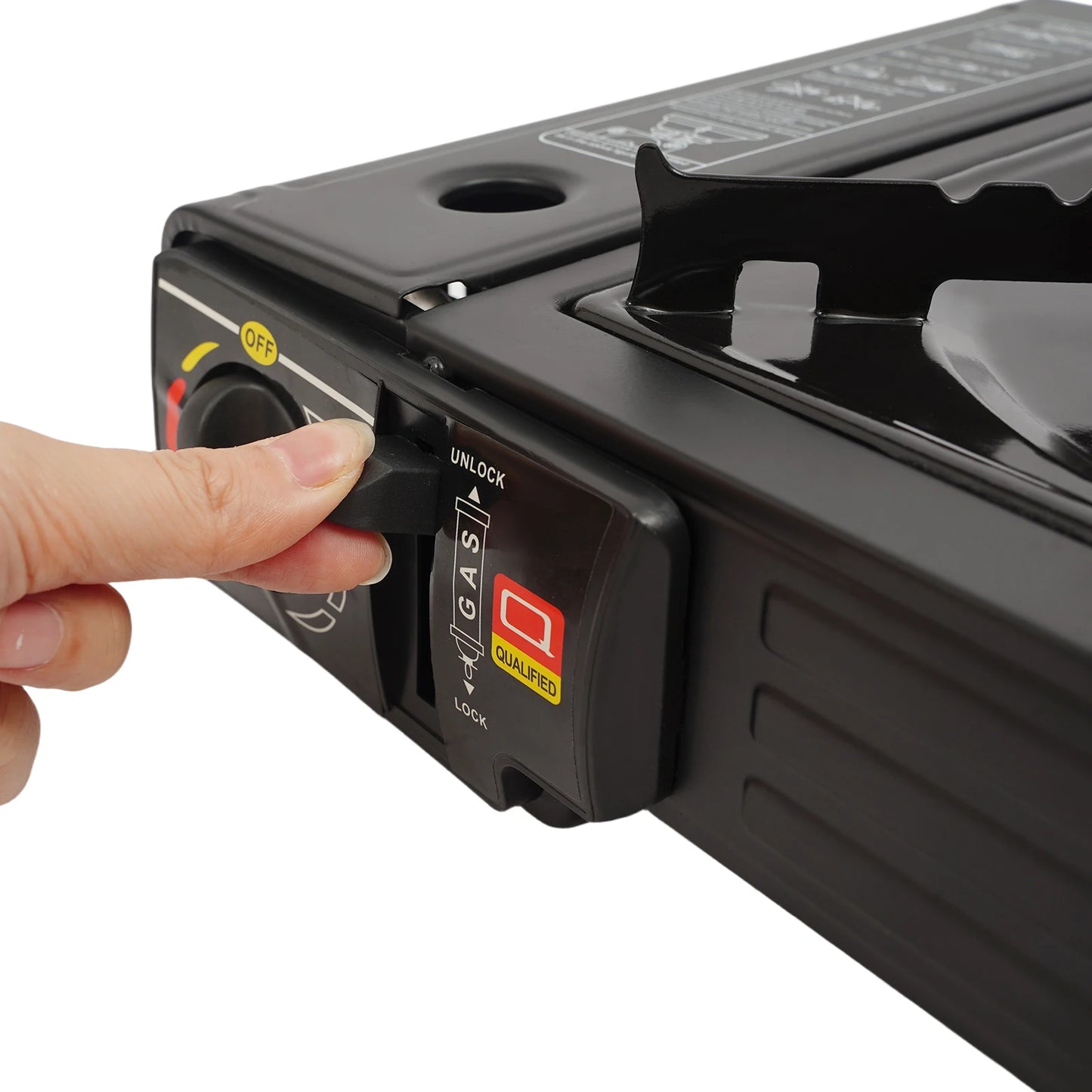 Hand pressing a button on a black portable stove with a white background
