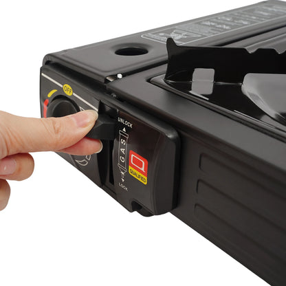 Hand pressing a button on a black portable stove with a white background