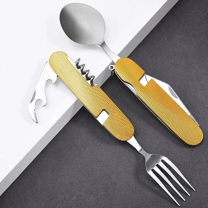A set of stainless steel cutlery with textured gold handles, including a spoon, fork, and corkscrew, arranged diagonally on a white and dark gray surface.
