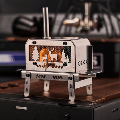 Portable metal stove with deer and forest design on a wooden surface