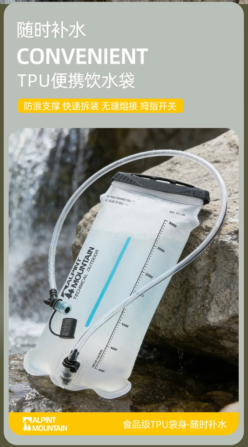 A transparent TPU portable water bottle bag with a clear drinking tube, shown resting on rocks near water. The bag has printed measurement markings and a black cap, with Chinese marketing text at the top and a yellow brand strip at the bottom reading MOUNTAIN.