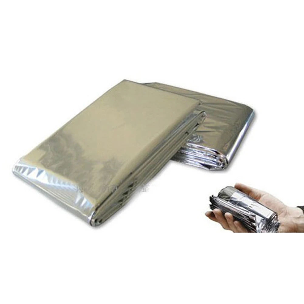 Folded mylar blanket with a hand holding it on a white background