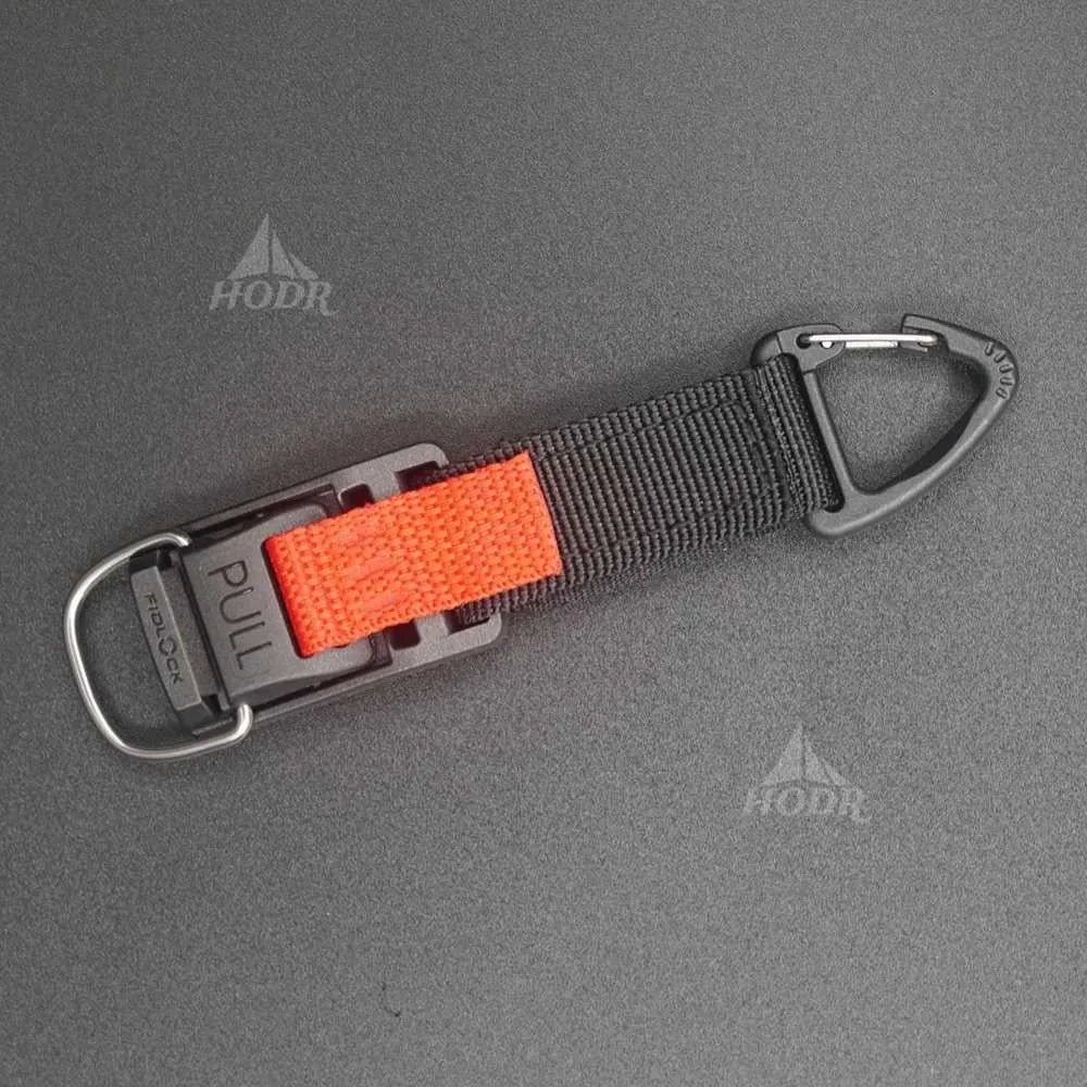 A black webbed strap with a bright orange textured pull tab and gray metal carabiner hardware, shown on a dark gray textured background with HODR watermarks.