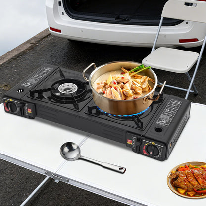 Portable camping stove with a pot of food on a table next to an open car trunk.