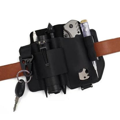 Black multi-tool belt pouch with various tools and a key on a white background