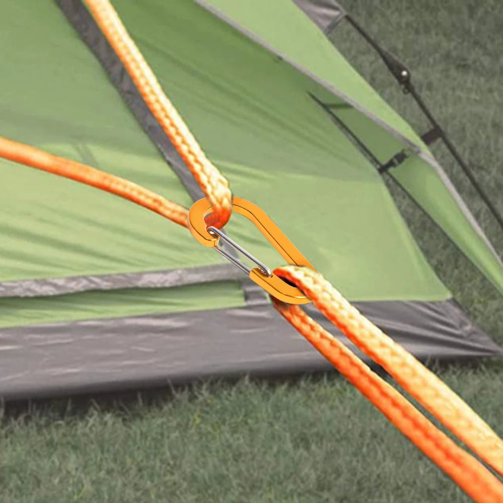 Green tent with orange ropes and carabiners on grass